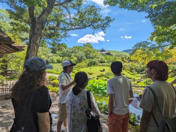 Students engaging with our tour guide at the Yoshikien Garden in Nara, Japan.