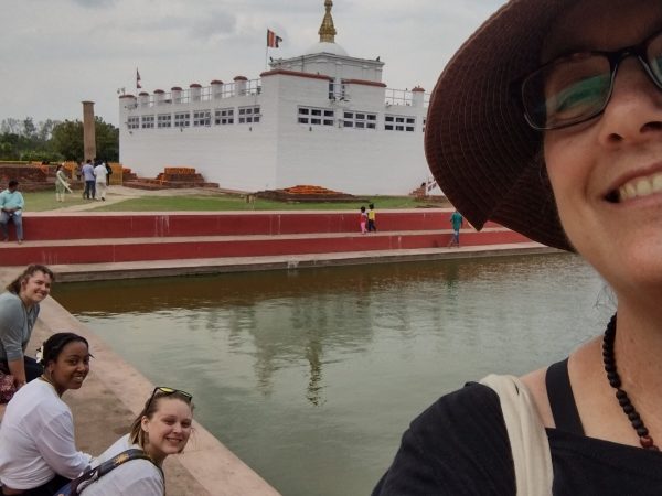 (Left to Right) Delaney Scott, Jordyn Shumpert, Kai Miller, and Dr. Suzanne Bessenger in front of the Maya Devi Temple in Lumbini, Nepal. Buddhist tradition states this is where Queen Maya gave birth Prince Siddhartha, who became Shakyamuni Buddha. This temple is at one end of an international monastic zone, where the Student Faculty Fellow team talked with nuns and monks.