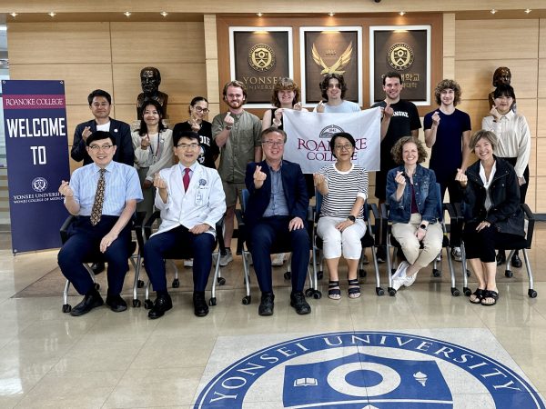 Roanoke College students and Yonsei University Wonju College of Medicine administrators and physicians signal "love".